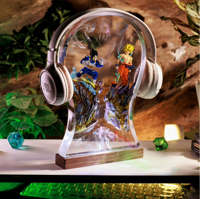 Anime-inspired headphone stand with glowing Goku and Vegeta figurines in transparent head design