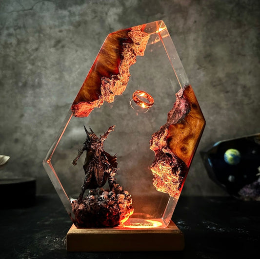 Hexagonal resin art diorama featuring dark fantasy scene with glowing ring, lava-like elements, and menacing warrior figure on illuminated wooden base