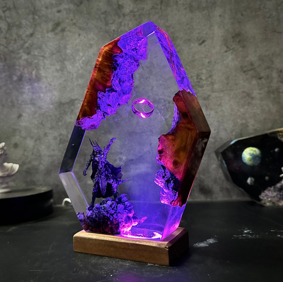 Otherworldly resin art: ethereal ring suspended in hexagonal prism above fiery caverns and dark sentinel, mounted on glowing base