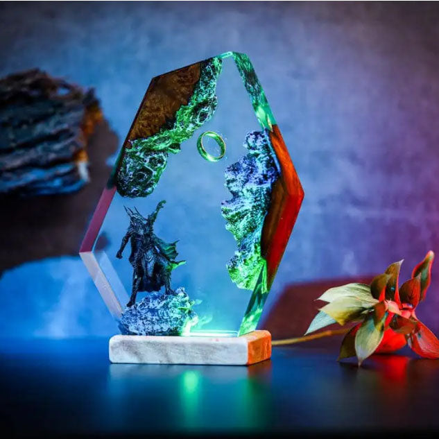 Fantasy resin lamp with dark armored figure, floating ring, and lava-like elements in hexagonal display, lit from below